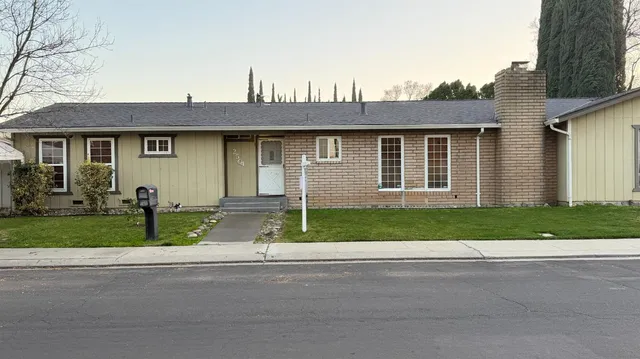 a front view of a house with a garden and plants