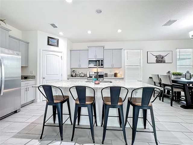 a kitchen with stainless steel appliances granite countertop a sink a stove and microwave