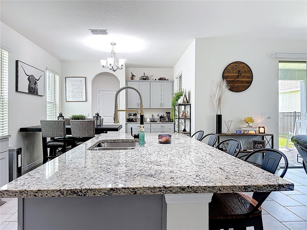 16632 Point Rock Drive Winter Garden, FL 34787 - Photo 15 of 74 a kitchen with kitchen island granite countertop a table and chairs in it