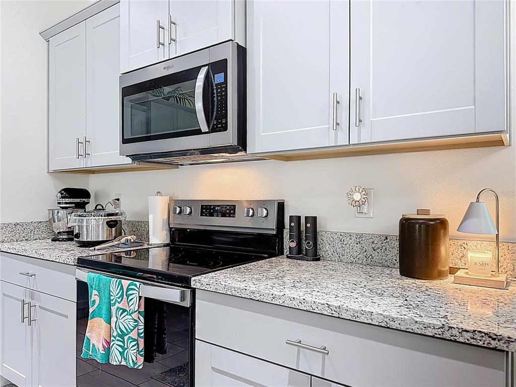 16632 Point Rock Drive Winter Garden, FL 34787 - Photo 17 of 74 a kitchen with stainless steel appliances granite countertop a sink a stove and microwave