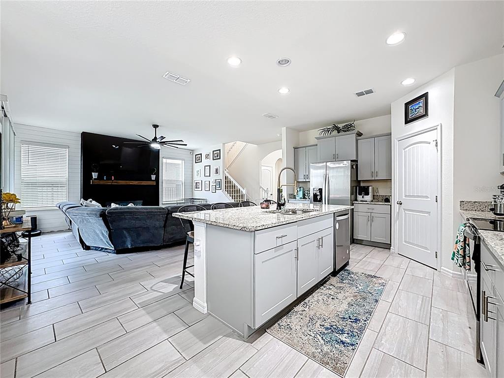 16632 Point Rock Drive Winter Garden, FL 34787 - Photo 18 of 74 a kitchen with stainless steel appliances kitchen island granite countertop a sink and a stove top oven with white cabinets