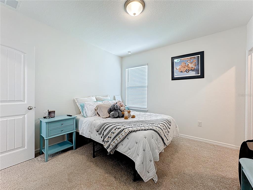 16632 Point Rock Drive Winter Garden, FL 34787 - Photo 30 of 74 a bedroom with a bed and a lamp