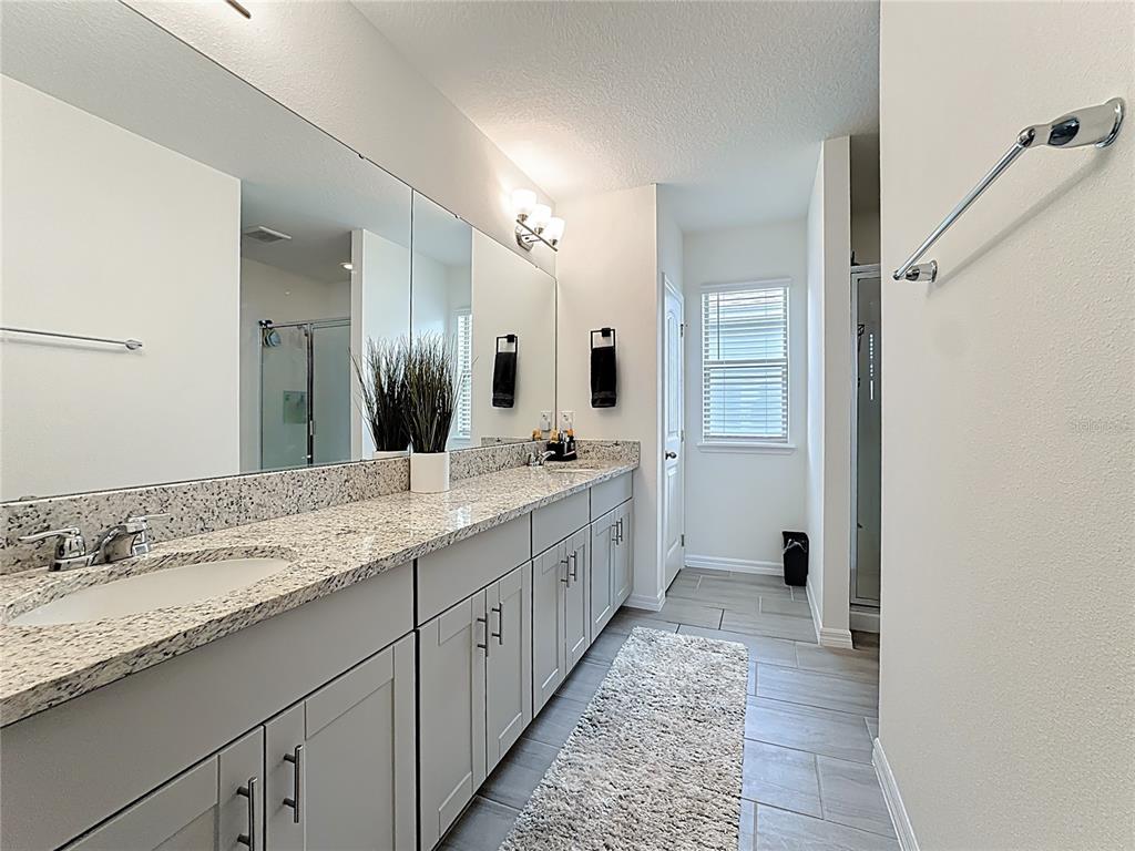 16632 Point Rock Drive Winter Garden, FL 34787 - Photo 39 of 74 a large bathroom with a granite countertop double vanity sink and a mirror