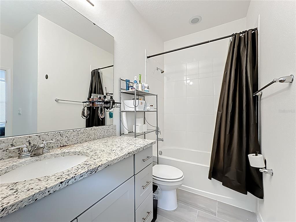 16632 Point Rock Drive Winter Garden, FL 34787 - Photo 53 of 74 a bathroom with a granite countertop sink toilet and shower