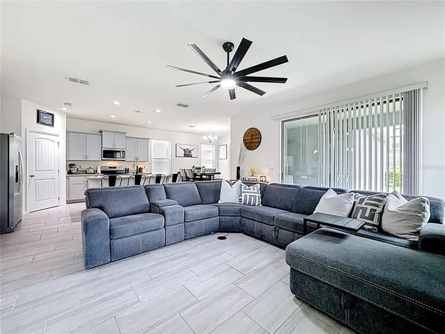 a kitchen with stainless steel appliances kitchen island granite countertop a table chairs sink refrigerator and cabinets