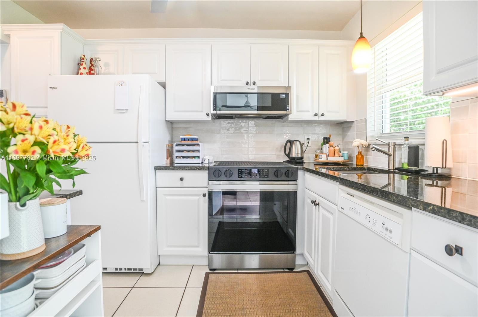 a kitchen with a white stove top oven and white cabinets