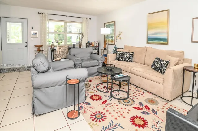 a dining room with stainless steel appliances kitchen island granite countertop a table chairs and a refrigerator