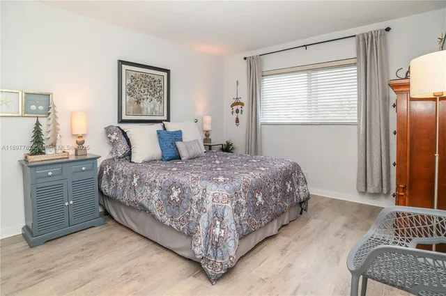 a large bed sitting in a bedroom with a lamp