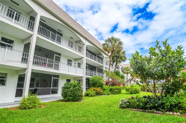 a group of people sitting in a yard in front of house
