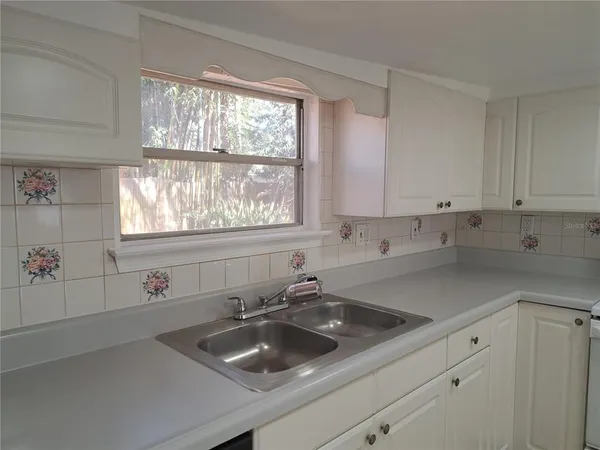 a kitchen with a sink cabinets and window