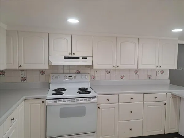 a kitchen with white cabinets and white appliances