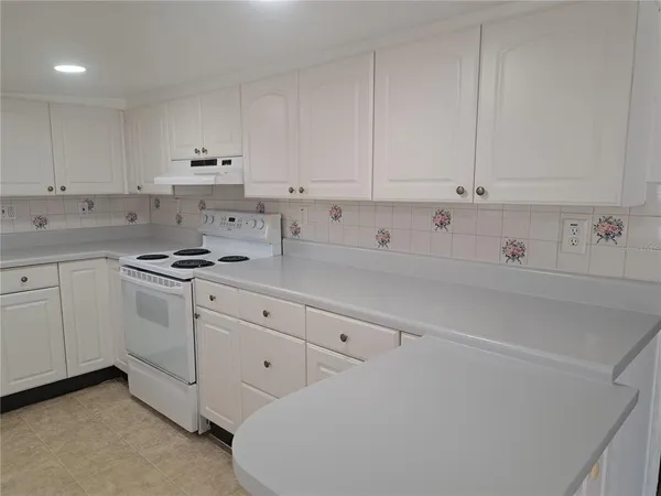 a kitchen with white cabinets and white appliances