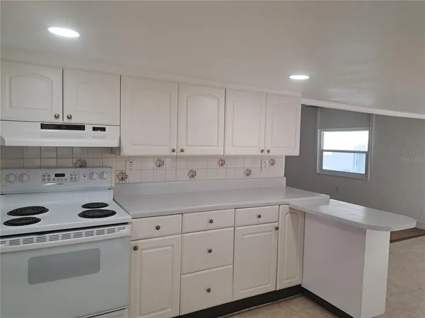 a kitchen with white cabinets and white appliances