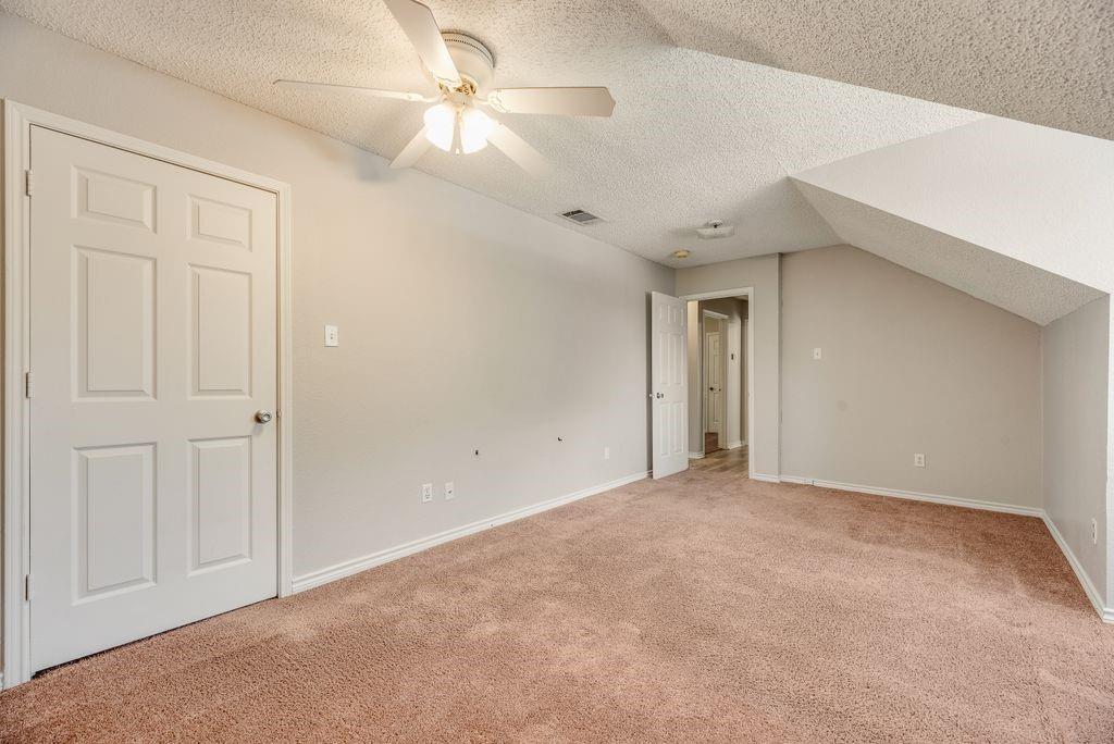 5610 Eagle Rock Road Arlington, TX 76017 - Photo 30 of 33 Carpeted room with sloped ceiling, ceiling fan with integrated lighting, and neutral wall paint