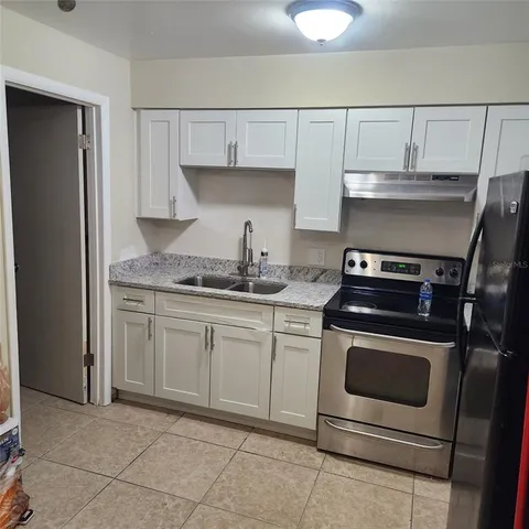 a kitchen with granite countertop white cabinets and white appliances