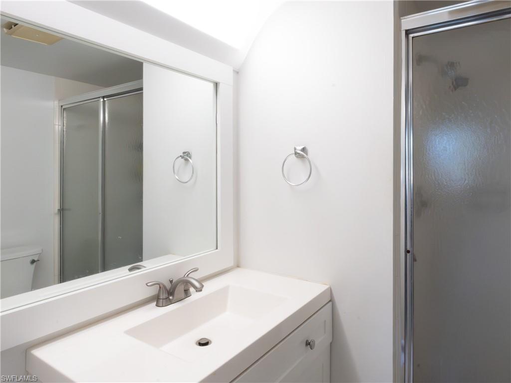 180 Turtle Lake Court, Unit 209 Naples, FL 34105 - Photo 3 of 12 a bathroom with a sink and a mirror