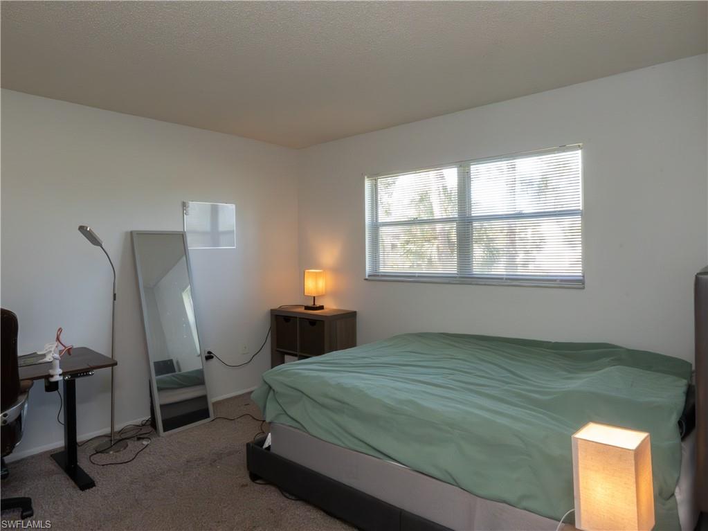180 Turtle Lake Court, Unit 209 Naples, FL 34105 - Photo 4 of 12 a bedroom with a bed and a window
