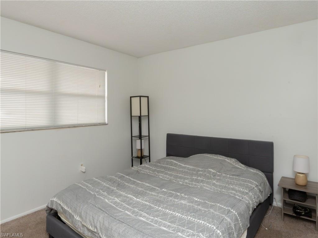 180 Turtle Lake Court, Unit 209 Naples, FL 34105 - Photo 6 of 12 a bedroom with a bed and a window