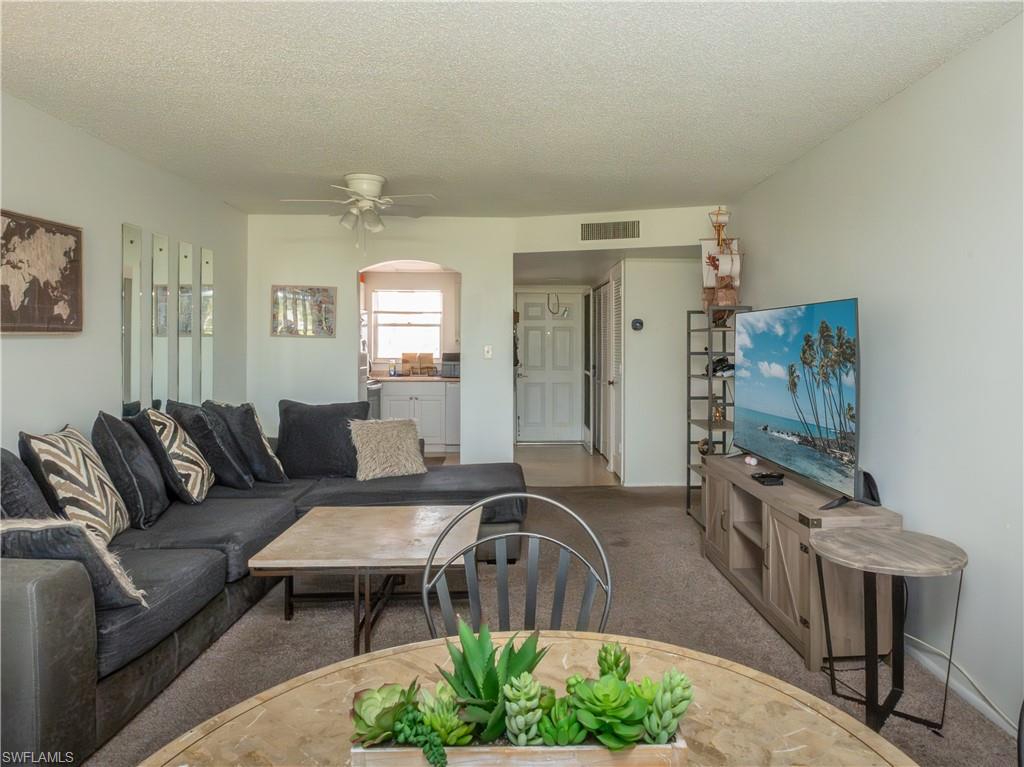 180 Turtle Lake Court, Unit 209 Naples, FL 34105 - Photo 7 of 12 a living room with furniture and a flat screen tv