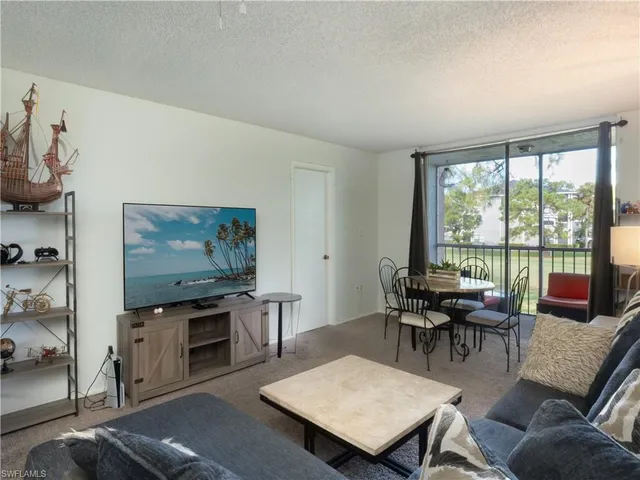 a living room with furniture a flat screen tv and a floor to ceiling window