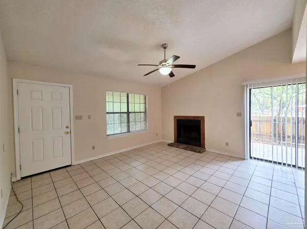 a view of an empty room with a window and a fireplace