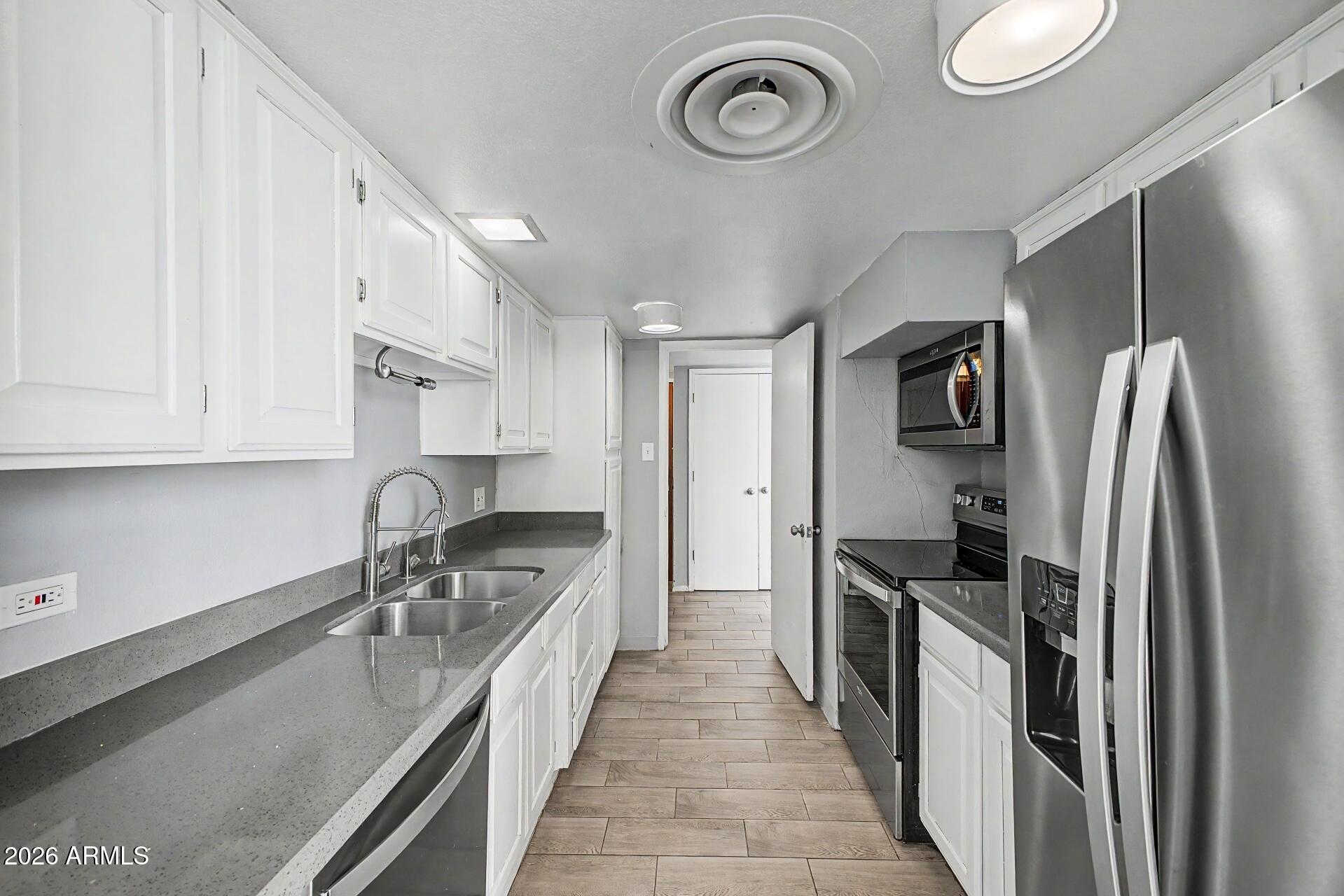 207 West Clarendon Avenue, Unit B2 Phoenix, AZ 85013 - Photo 8 of 30 a kitchen with stainless steel appliances granite countertop a sink stove and refrigerator