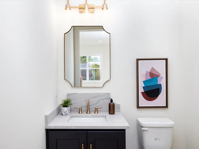 a spacious bathroom with a double vanity sink toilet mirror and shower