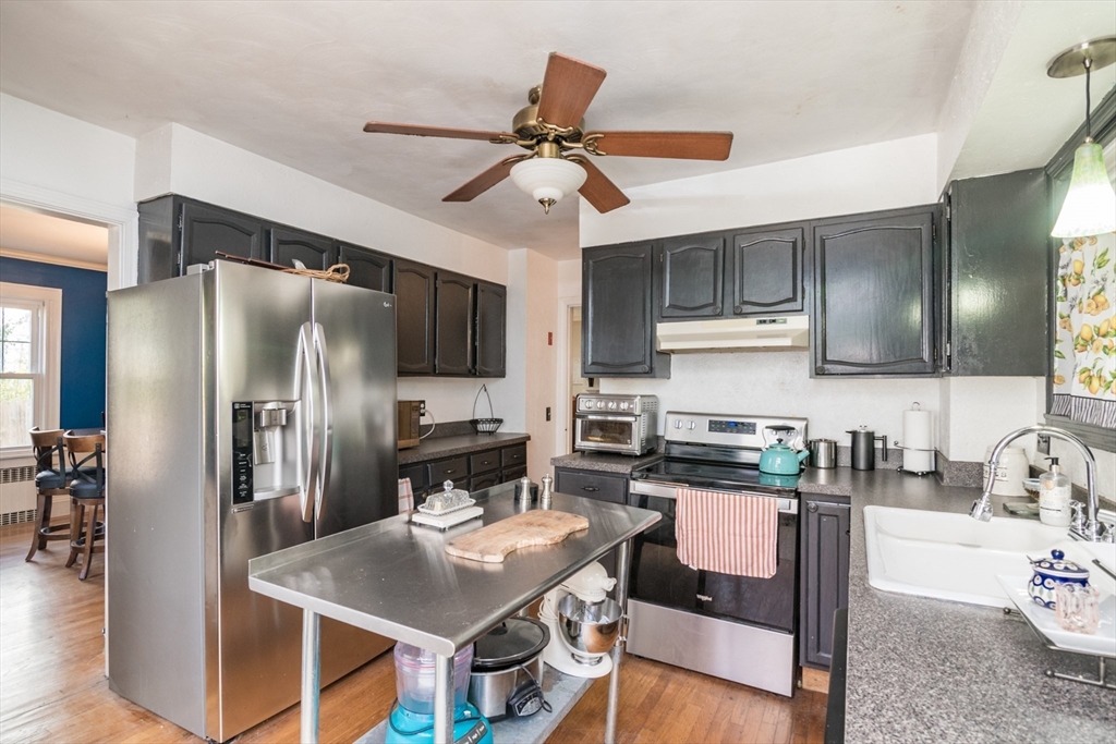 28 Rencelau Street Springfield, MA 01118 - Photo 15 of 34 a kitchen with stainless steel appliances granite countertop a refrigerator a stove a sink a dining table and chairs with wooden floor