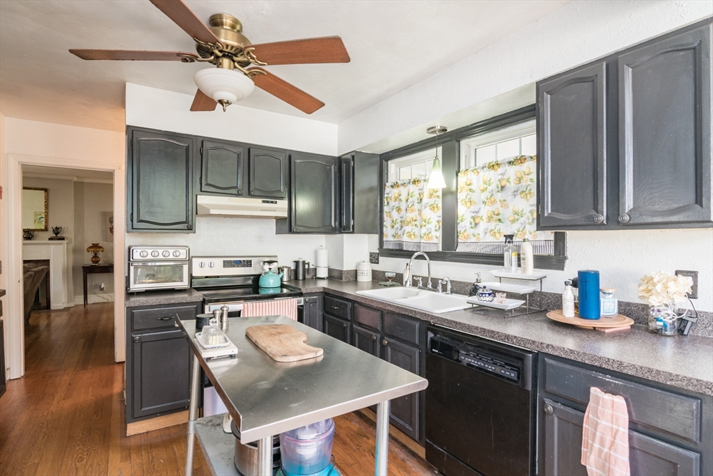 28 Rencelau Street Springfield, MA 01118 - Photo 16 of 34 a kitchen with stainless steel appliances granite countertop a sink a stove a refrigerator cabinets and a dining table