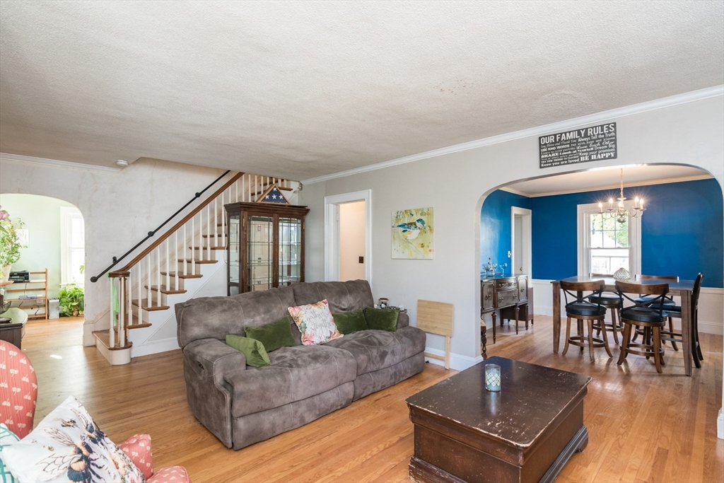 28 Rencelau Street Springfield, MA 01118 - Photo 9 of 34 a living room with furniture and a dining table with wooden floor