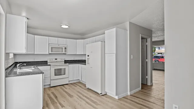 a kitchen with white cabinets and white appliances