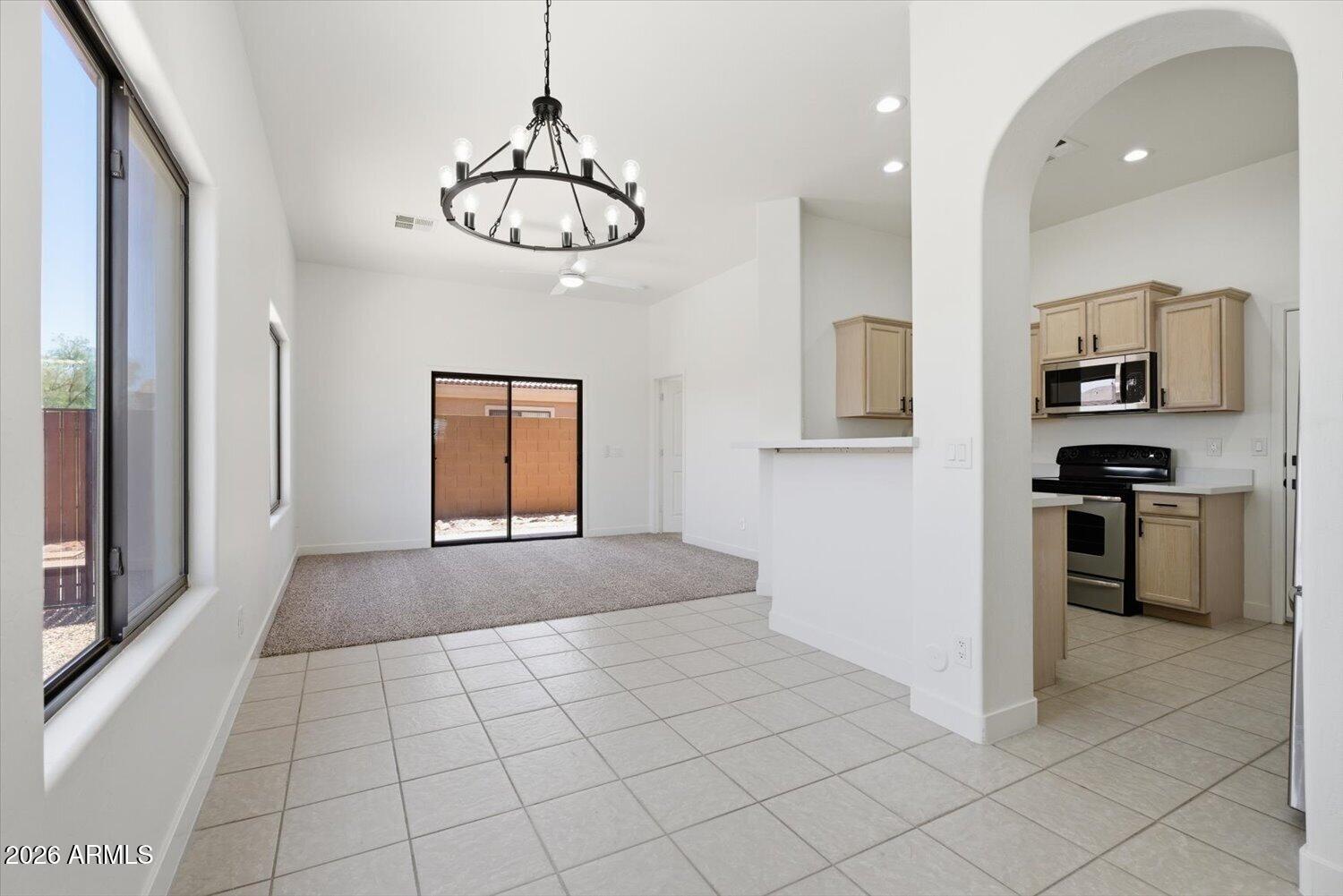 2565 South Signal Butte Road, Unit 23 Mesa, AZ 85209 - Photo 3 of 29 a view of an empty room with a window and kitchen view