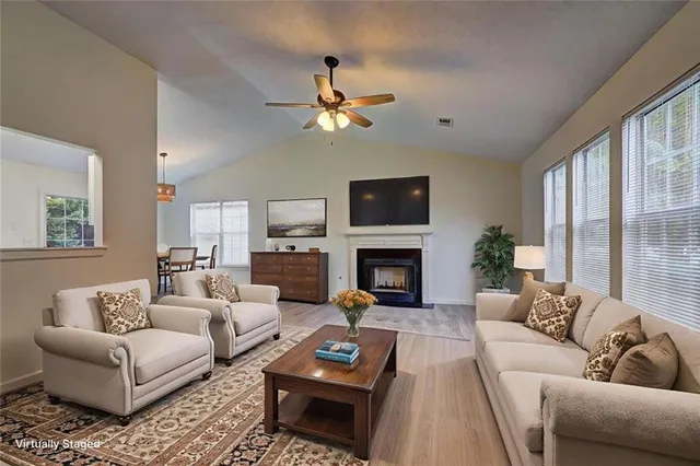a living room with furniture a fireplace and a flat screen tv