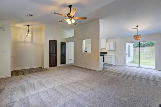 a view of empty room with window and ceiling fan