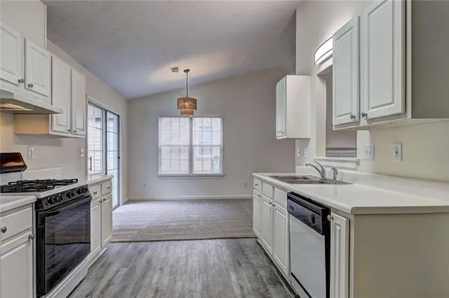 a kitchen with a sink stove top oven and cabinets