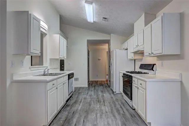 a kitchen with stainless steel appliances a sink stove and cabinets