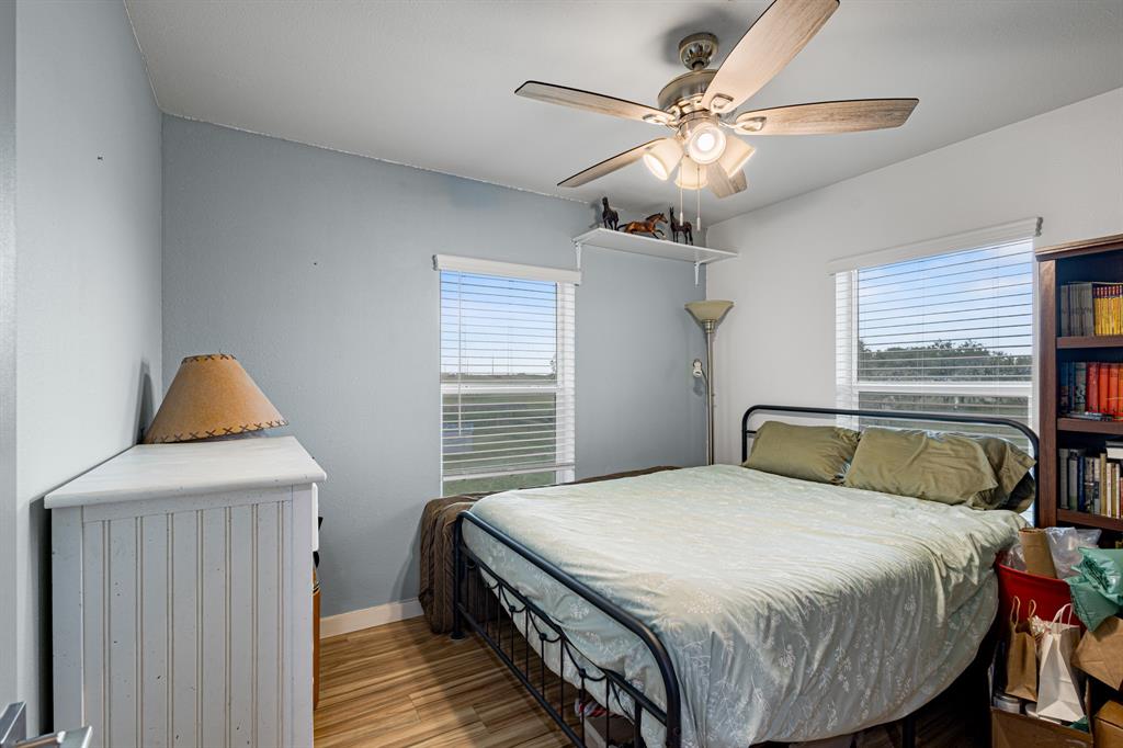 124 County Road 4511 Decatur, TX 76234 - Photo 26 of 39 a bedroom with a bed and a chandelier