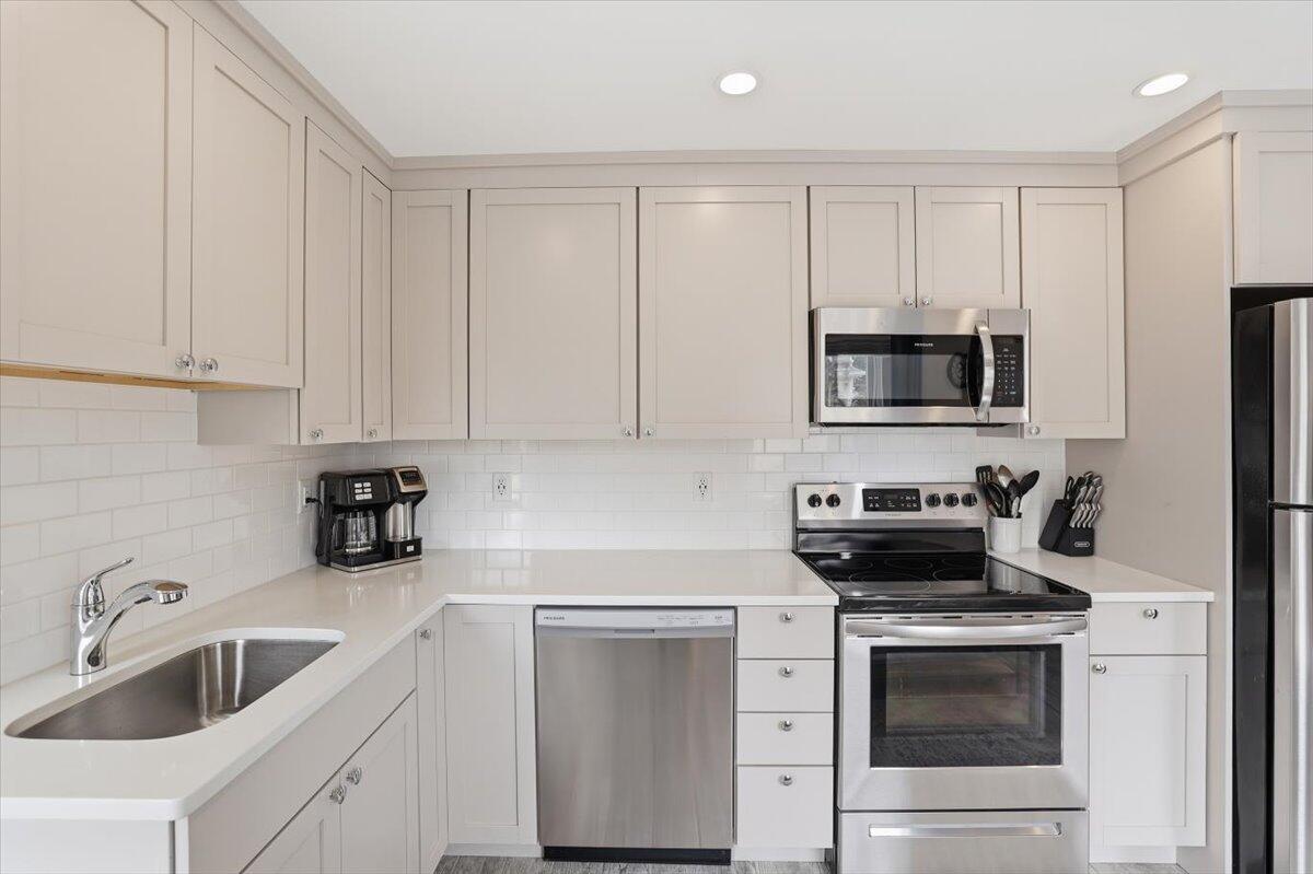 20 Nye Road, Unit 2026 Falmouth, MA 02540 - Photo 32 of 72 a kitchen with white cabinets stainless steel appliances and sink