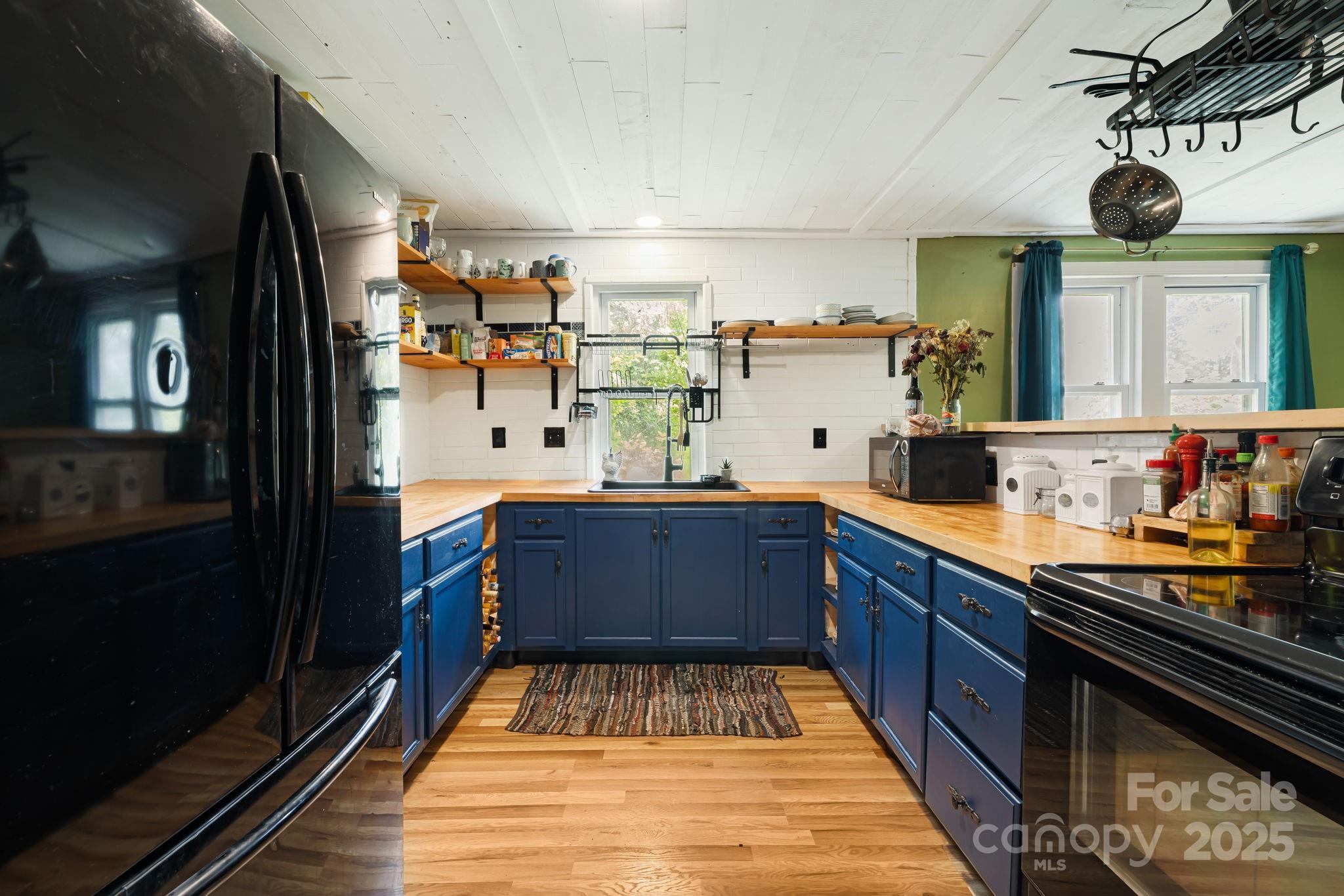 1271 Upper Brush Creek Road Fairview, NC 28730 - Photo 11 of 36 a kitchen with stainless steel appliances granite countertop a sink and cabinets
