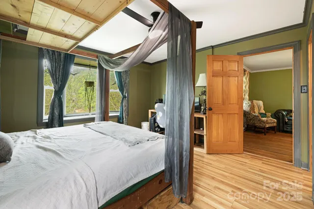 a bedroom with a bed and a large mirror with a wooden floor
