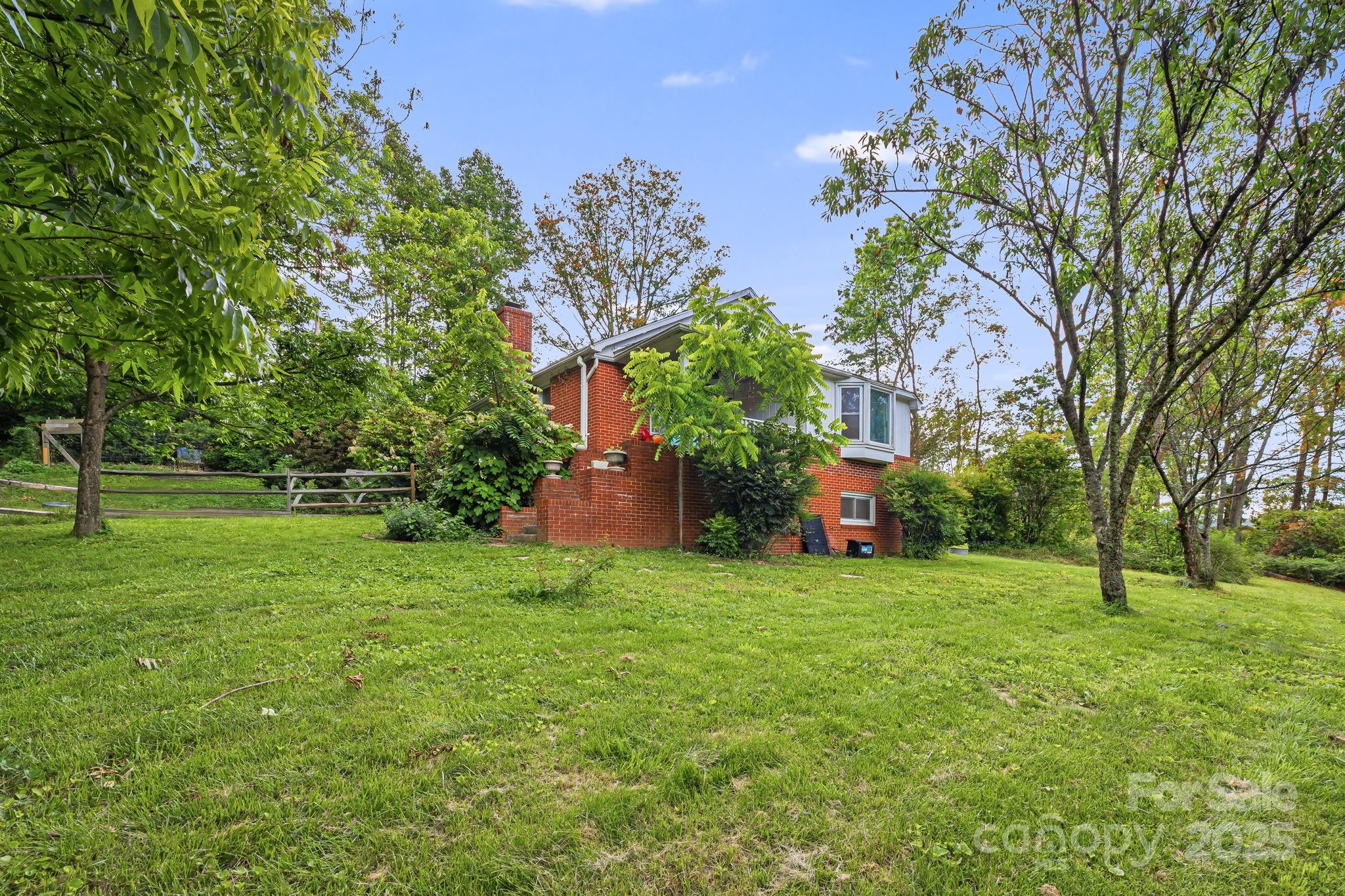 1271 Upper Brush Creek Road Fairview, NC 28730 - Photo 31 of 36 a view of a house with a big yard and large trees