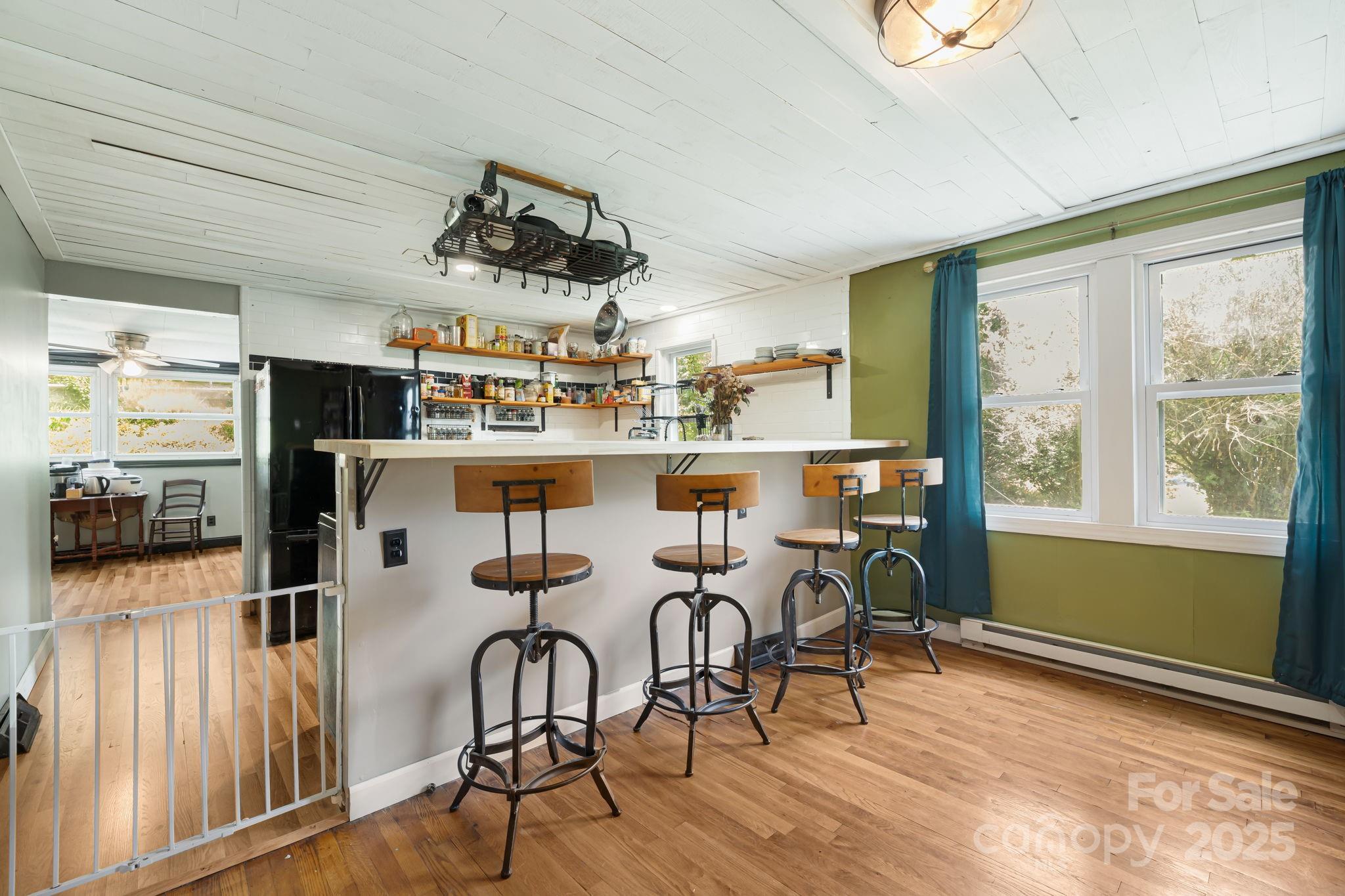 1271 Upper Brush Creek Road Fairview, NC 28730 - Photo 9 of 36 a room with stainless steel appliances a dining table chairs stove and large window