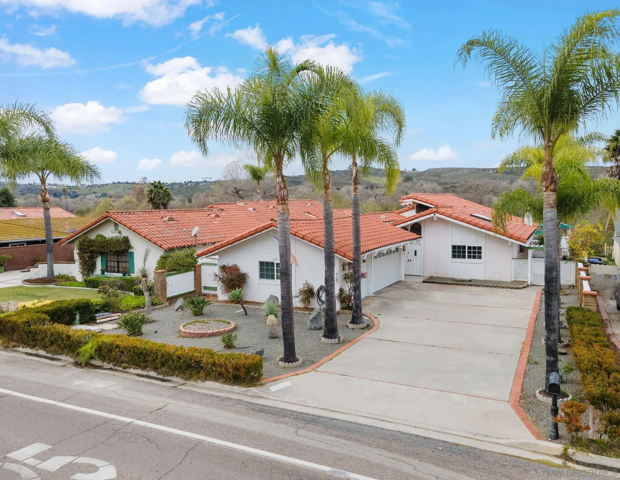 31162 Old River Road Bonsall, CA 92003 - Photo 1 of 44 a front view of a house with a yard and palm trees