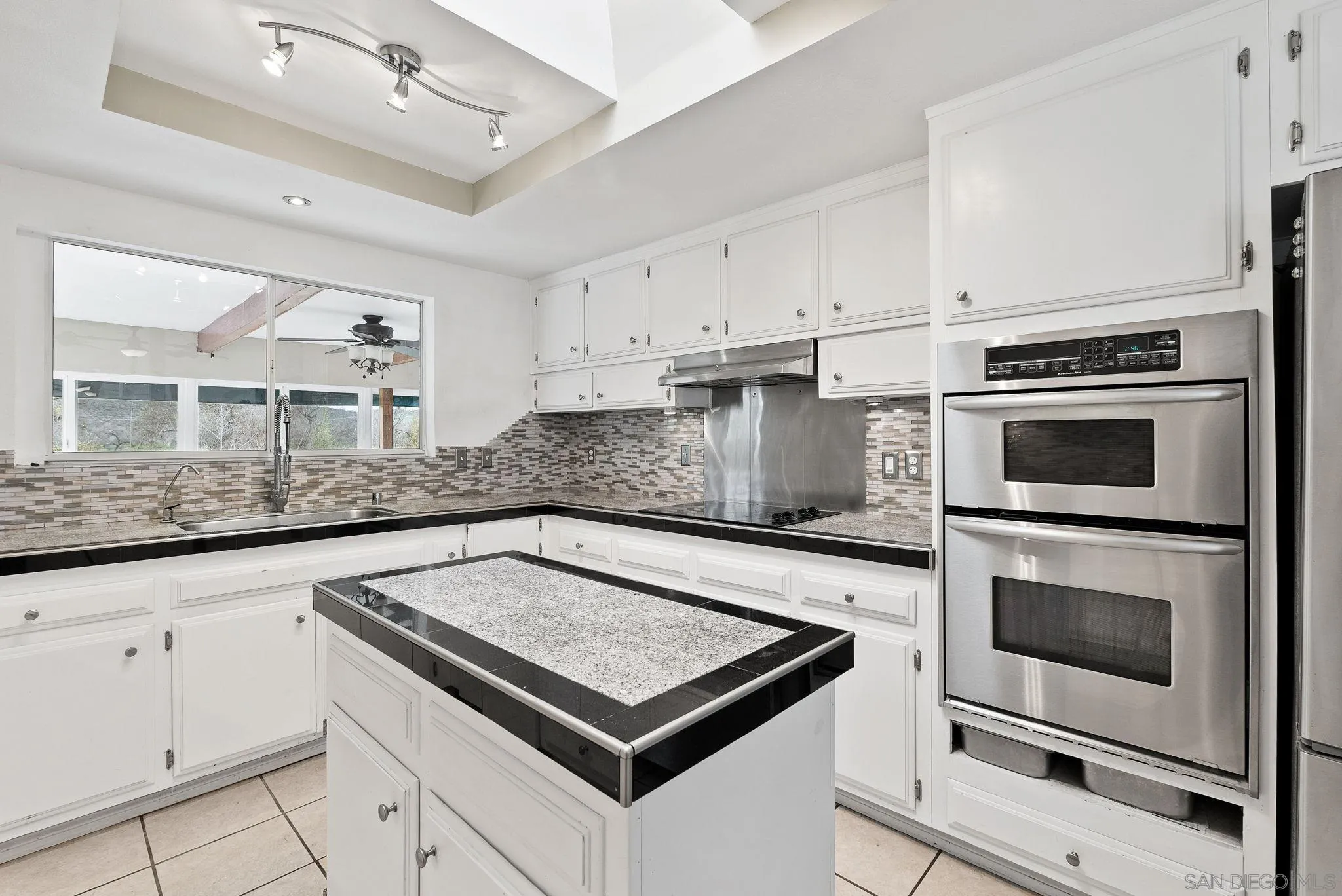 31162 Old River Road Bonsall, CA 92003 - Photo 34 of 44 a kitchen with granite countertop a stove cabinets and microwave