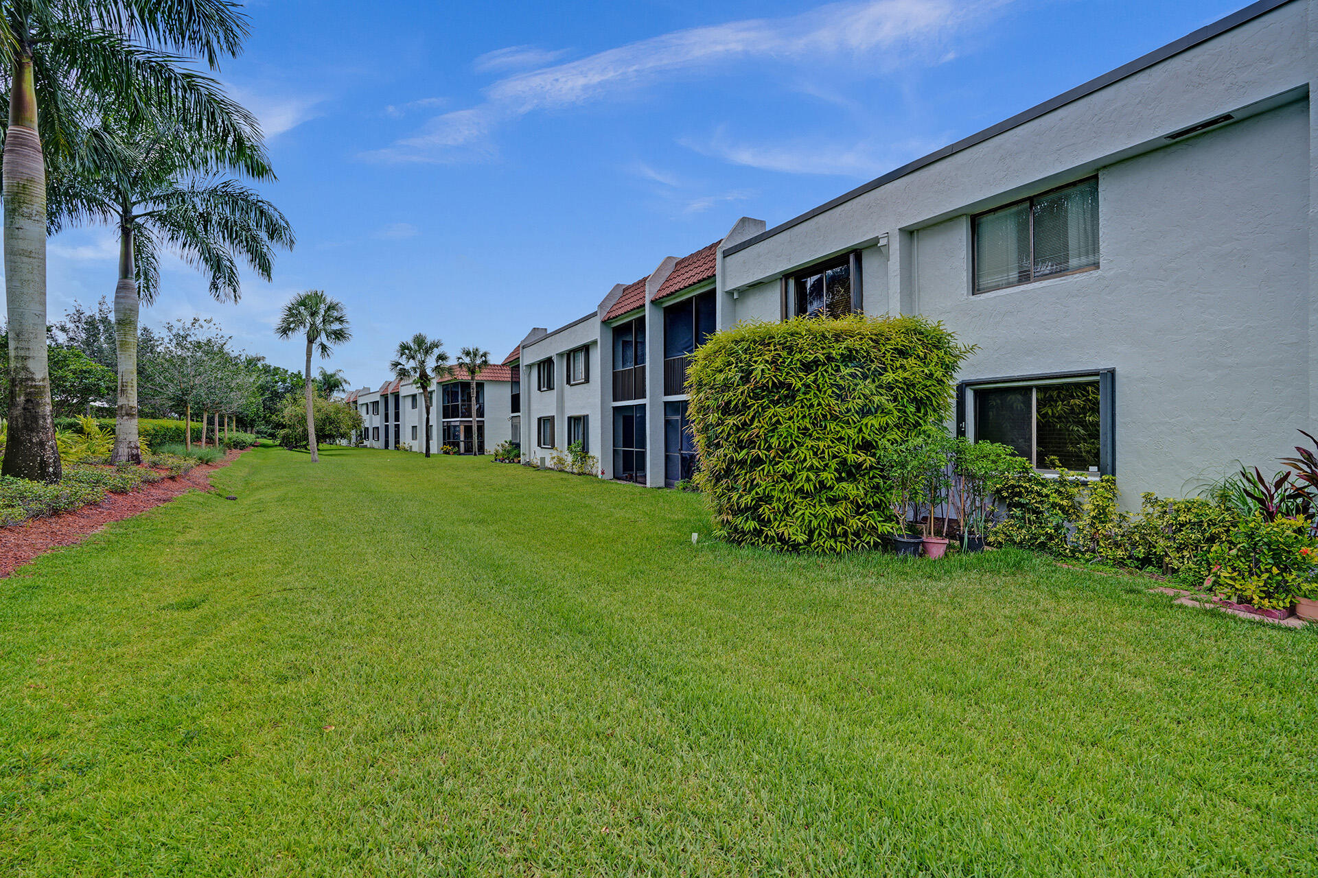 300 Racquet Club Road, Unit 103 Weston, FL 33326 - Photo 29 of 31 a view of a house with a big yard and palm trees