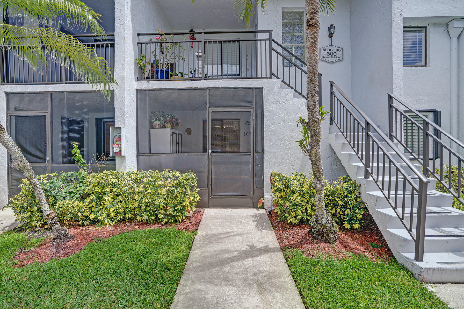 300 Racquet Club Road, Unit 103 Weston, FL 33326 - Photo 3 of 31 a view of a house with brick walls and a small yard