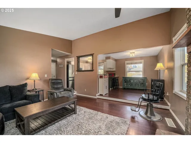a living room with furniture a dining table and wooden floor