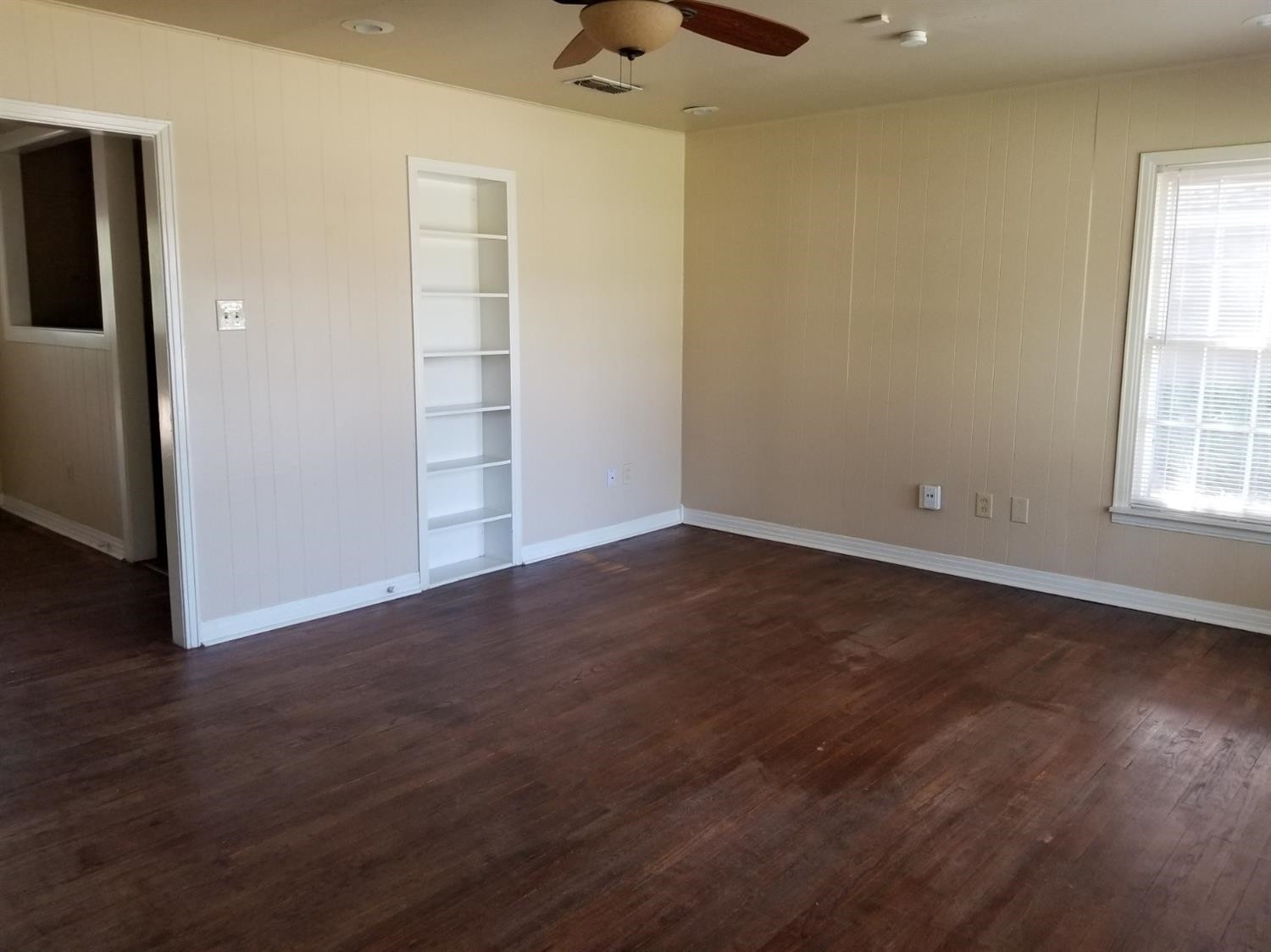 2621 27th Street Lubbock, TX 79410 - Photo 2 of 6 an empty room with wooden floor and windows