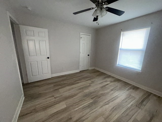 807 Erin Street El Campo, TX 77437 - Photo 11 of 13 wooden floor in an empty room with a window