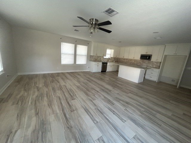 807 Erin Street El Campo, TX 77437 - Photo 5 of 13 an empty room with wooden floor and windows